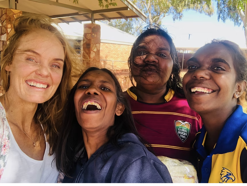 Verity laughing with Aboriginal women during community work
